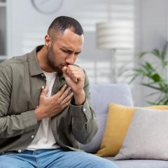 Man coughs and holds his chest
